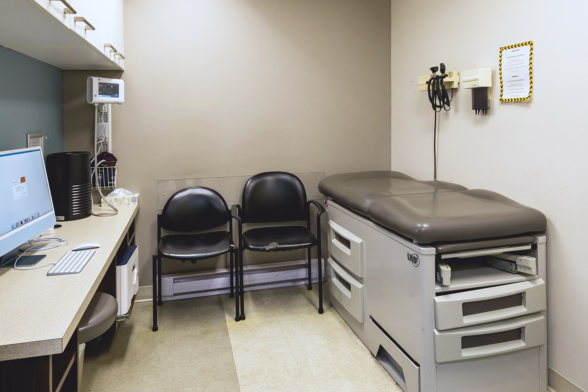 Exam room with exam table and desk